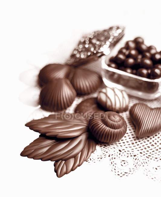 Chocolates and chocolate leaves — Stock Photo