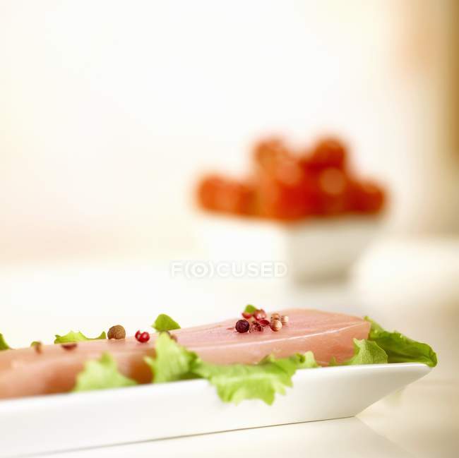 Vista de primer plano del filete de pez espada con ensalada y especias en plato blanco - foto de stock