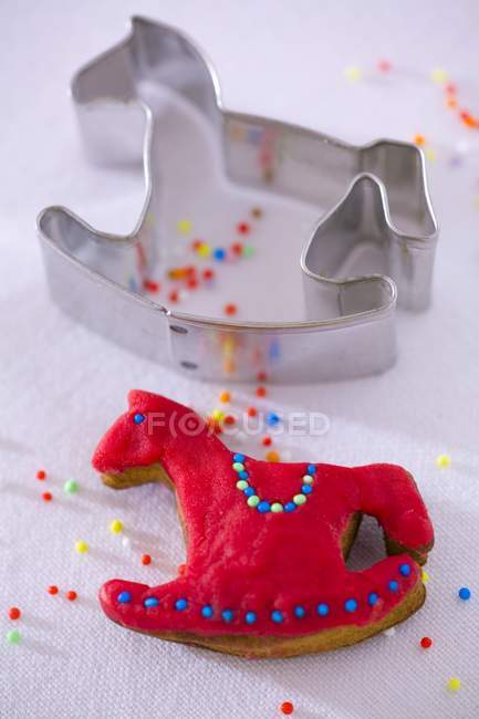 Closeup view of rocking horse biscuit with cutter and sprinkles — Stock Photo