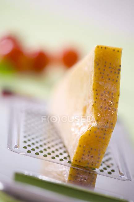 Pedazo de parmesano en el rallador - foto de stock