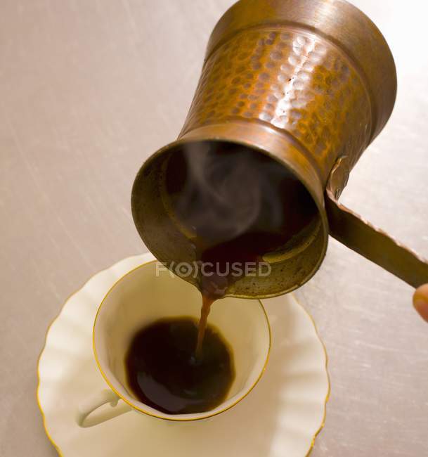 Verter el café turco en la taza - foto de stock