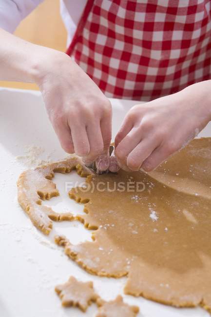 Mani che tagliano biscotti — Foto stock