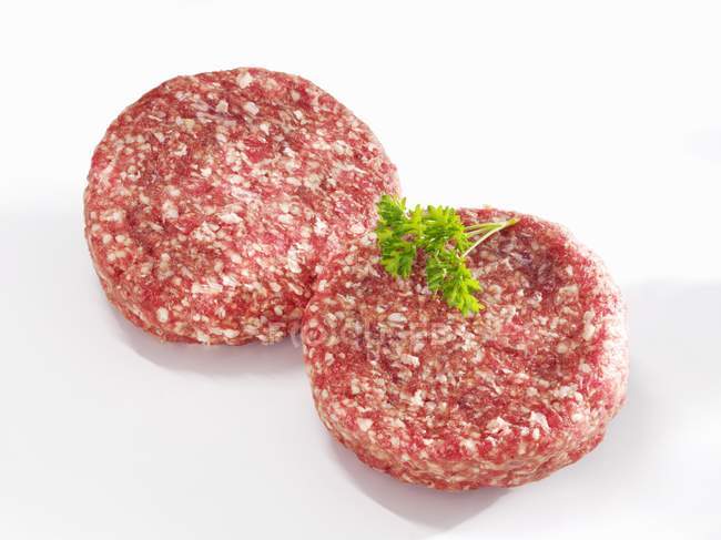 Raw beefburgers with herb — Stock Photo