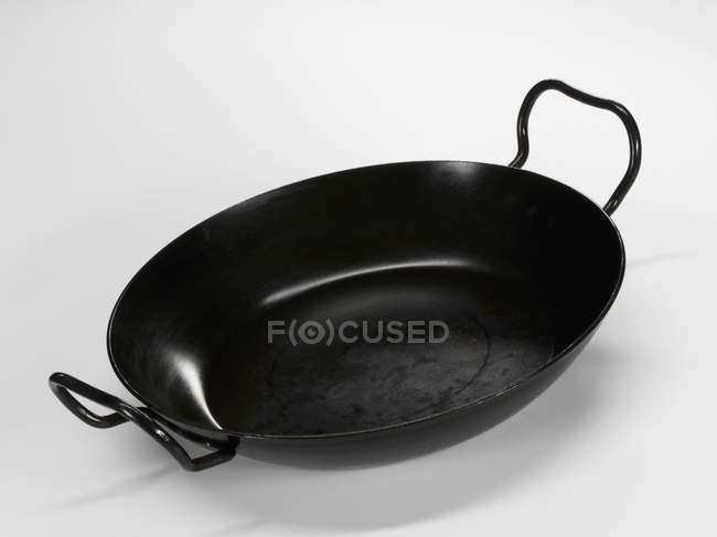 Вид крупным планом одной черной сковороды на белой поверхности — стоковое фото