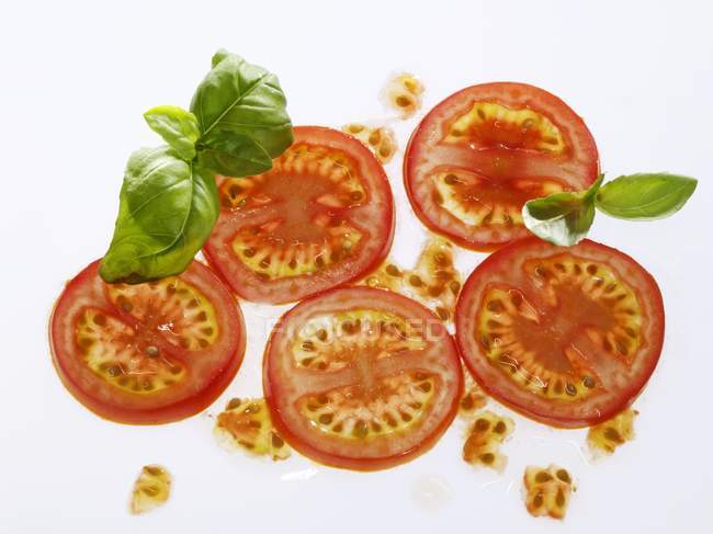 Tomato slices and basil — Stock Photo