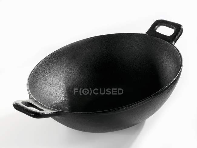 Vue rapprochée d'un wok noir sur une surface blanche — Photo de stock
