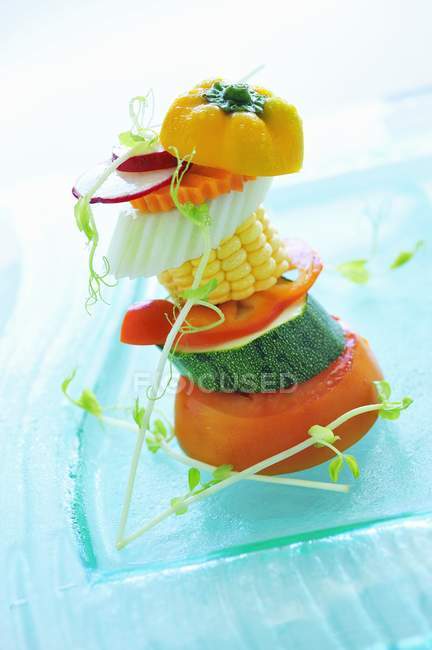 Torre di verdure assortite su piatto di vetro blu — Foto stock