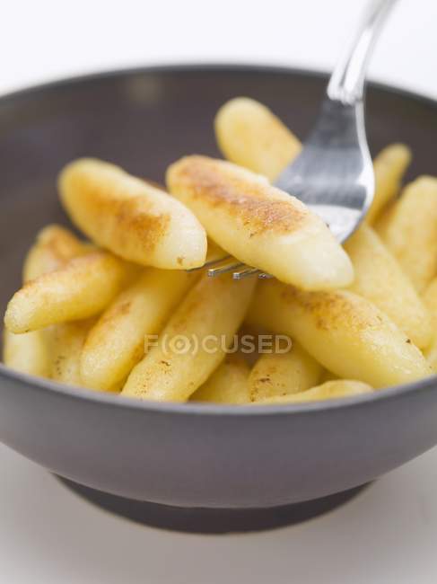 Potato noodles in bowl with fork — Stock Photo
