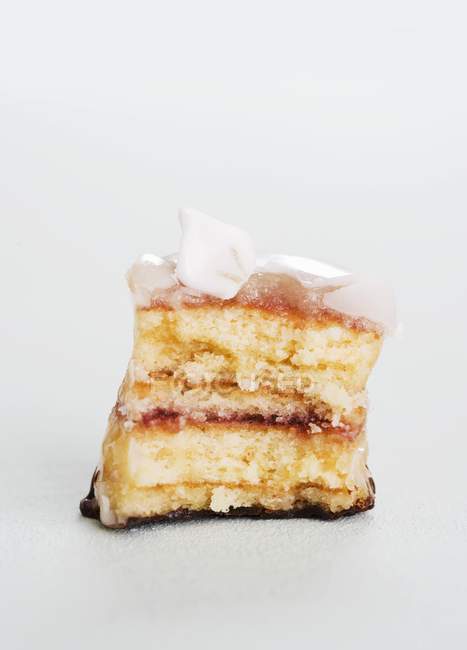 Nahaufnahme von teilweise gegessen Petit Four mit Zuckerblume — Stockfoto