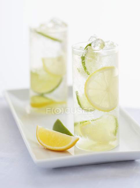 Deux verres d'eau Selzer avec des tranches de citron et de chaux — Photo de stock