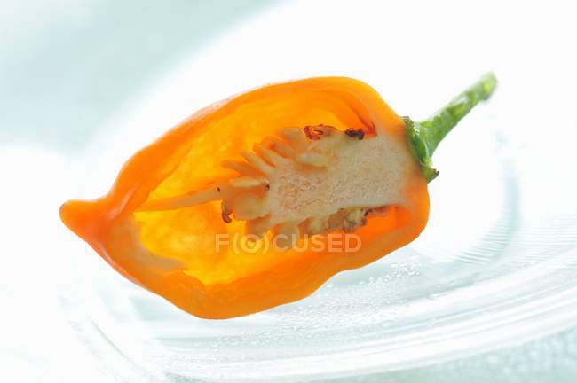 Metà di un piccolo peperoncino giallo su lastra di vetro — Foto stock