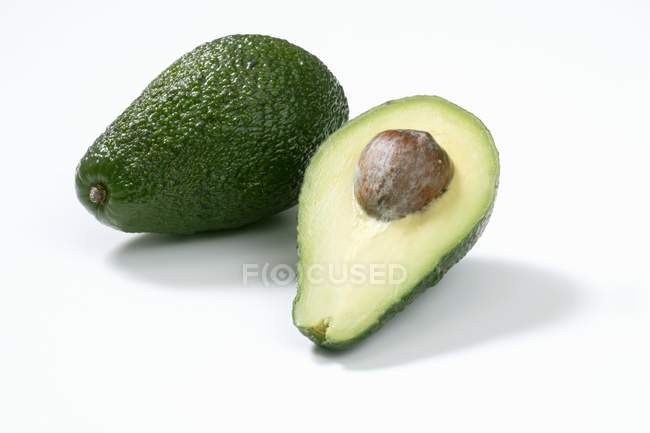 Whole and half avocado — Stock Photo
