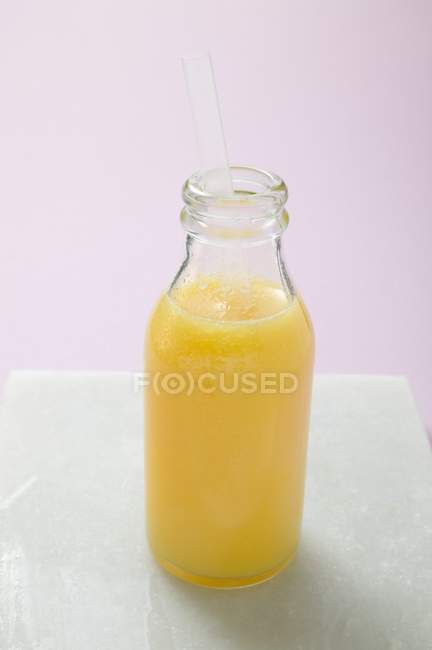Orange juice in glass bottle — Stock Photo