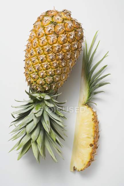 Whole pineapple with wedge of pineapple — Stock Photo