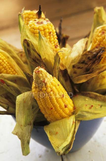 Vista de cerca de mazorcas de maíz a la parrilla con chile - foto de stock