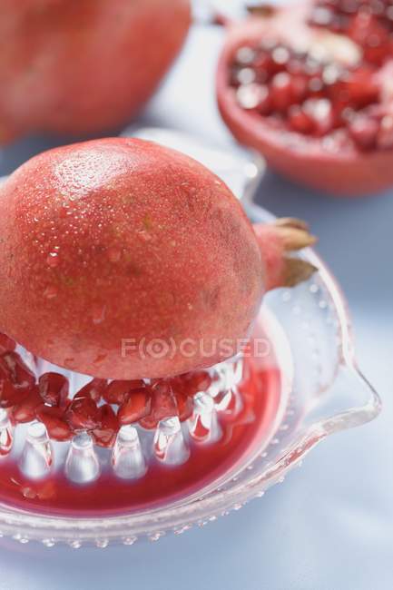 Fruta de granada en el exprimidor - foto de stock