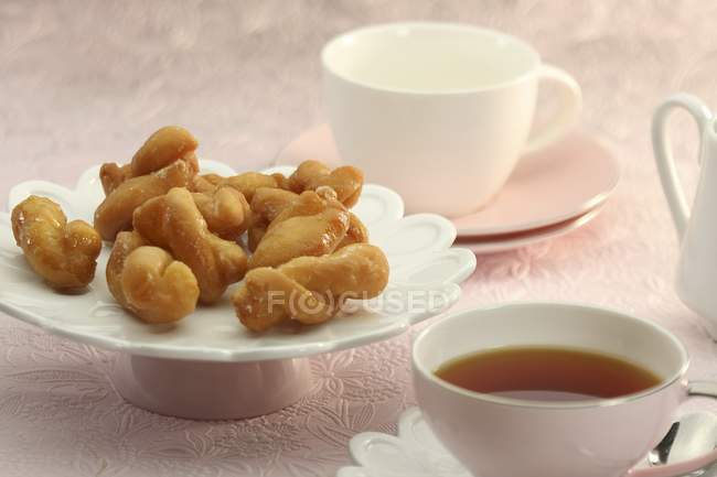 Koeksisters avec du thé dans l'assiette — Photo de stock