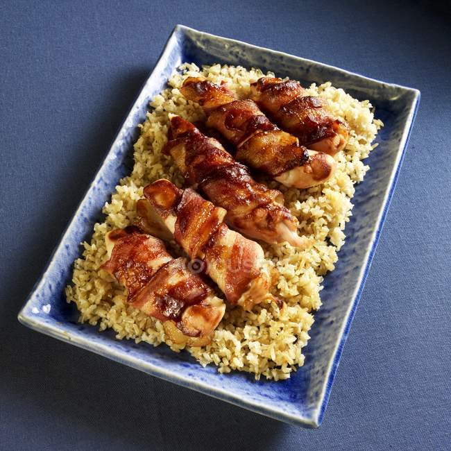 Bacon wrapped chicken on rice — Stock Photo