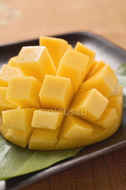 Mango tagliato a dadini fresco in cubi su pelle — Foto stock