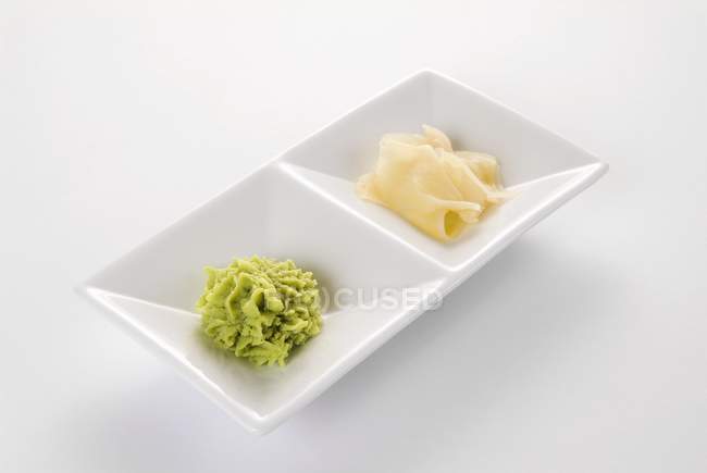 Vue rapprochée du Wasabi et du gingembre mariné dans un plat blanc — Photo de stock