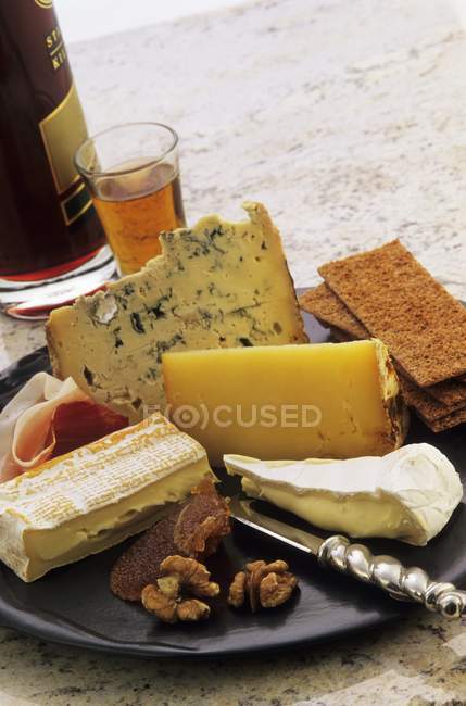 Cheese platter with nuts — Stock Photo