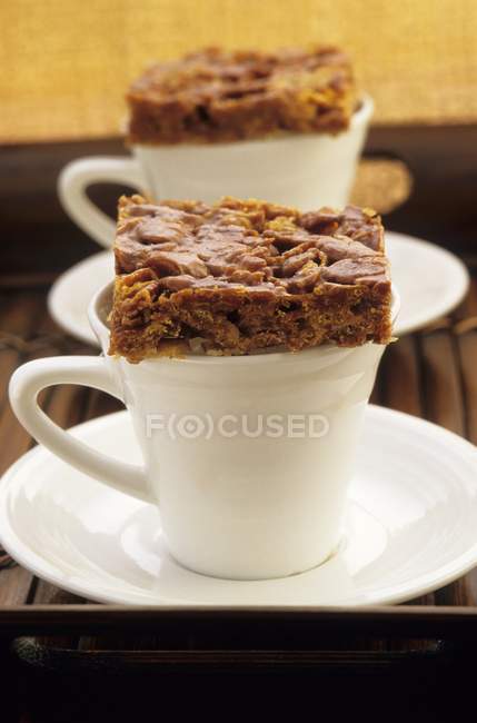 Primo piano vista di fette di caramello su tazze di caffè — Foto stock
