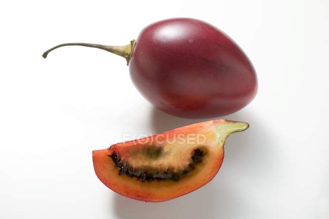 Fruta de tamarilla entera con cuña - foto de stock