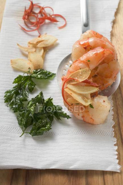 Garlic prawns on slotted spoon — Stock Photo