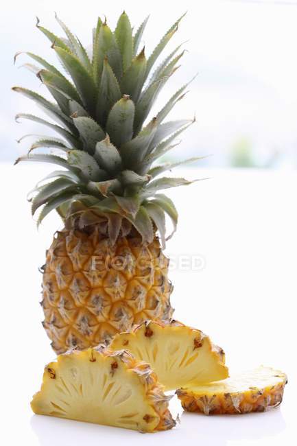 Whole pineapple and pineapple slices — Stock Photo