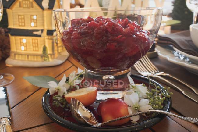 Vue rapprochée de la sauce aux canneberges aux pommes et fleurs sur la table de Noël — Photo de stock