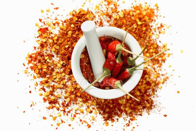Dried chili peppers and chili flakes — Stock Photo
