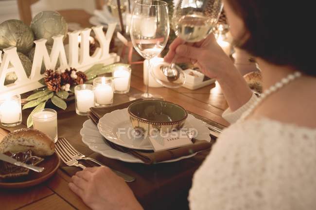 Woman drinking white wine at Christmas meal — Stock Photo