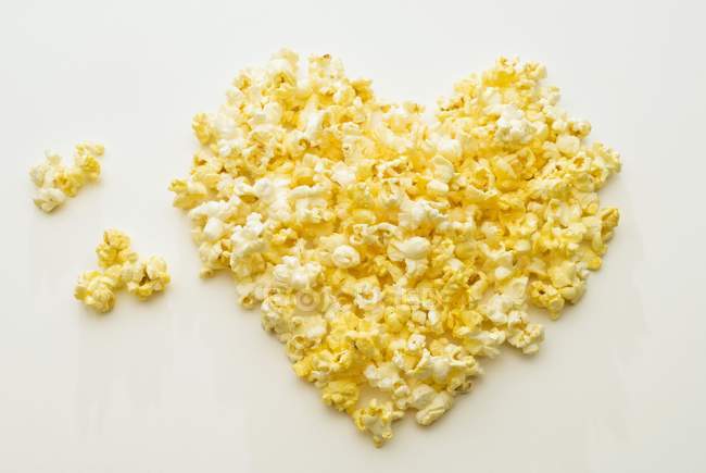 Сердце попкорна на белом — стоковое фото
