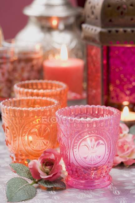 Vista de primer plano de las velas encendidas en los parabrisas con rosas y linterna - foto de stock
