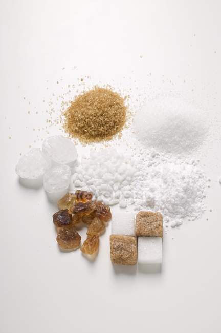Verschiedene Arten von Zucker auf weißer Oberfläche — Stockfoto