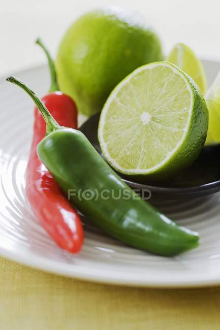 Limes with chili peppers — Stock Photo