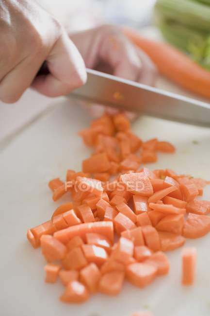 Main humaine hacher des carottes — Photo de stock