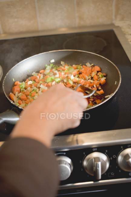 Человеческая рука Sauting морковь и сельдерей — стоковое фото