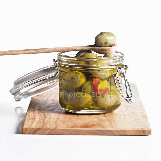 Green olives in preserving jar — Stock Photo