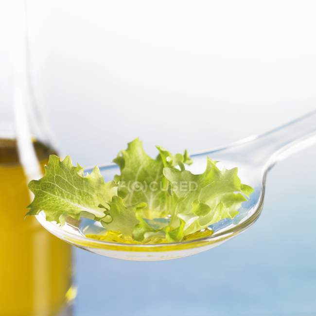 Lettuce leaf with oil on spoon — Stock Photo