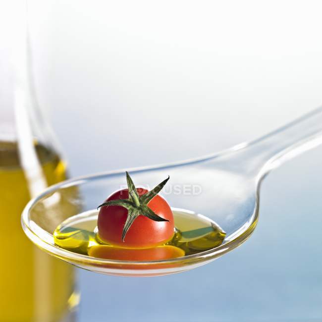 Cocktail tomate com óleo sobre colher sobre fundo azul — Fotografia de Stock