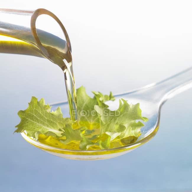 Öl läuft auf Salatblatt — Stockfoto