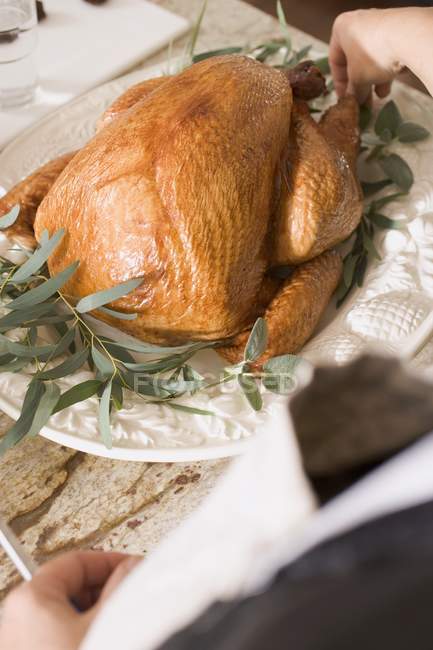 Woman garnishing roast turkey — Stock Photo