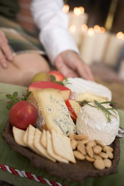 Planche à fromage pour servir les mains — Photo de stock