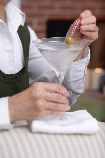 Bar tender holding glass of Martini — Stock Photo