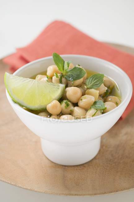 Chick-peas with lime wedge and herbs — Stock Photo