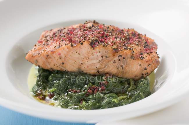 Filetto di salmone piccante sugli spinaci — Foto stock