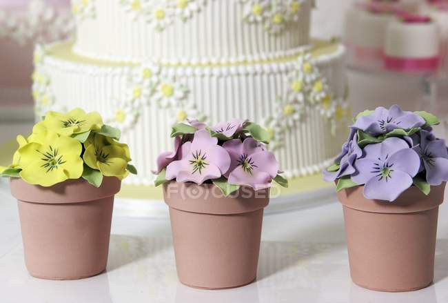 Wedding cake and artificial pansies — Stock Photo