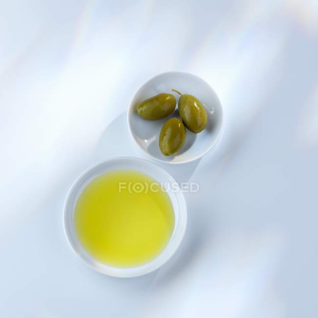 Olivenöl und grüne Oliven — Stockfoto
