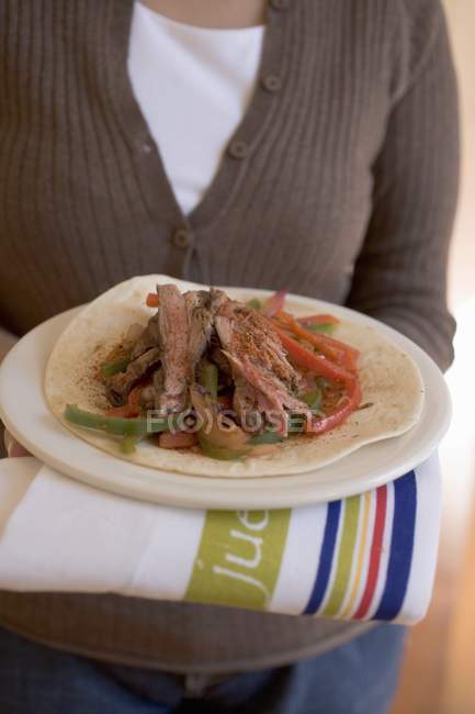 Woman holding beef tortilla — Stock Photo